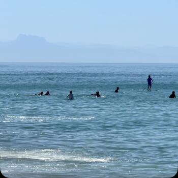 Waiting for the next set to roll in, under the blue sky and bright sun. Quiksilver Contest to the right at La Nord, and the